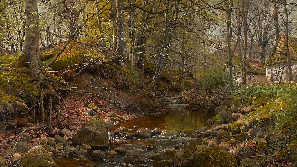 A forest during the fall with a rocky stream and a white house across the stream.