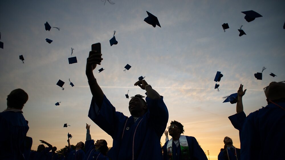 High school students throwing their graduation caps in celebration.