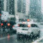 This is a photograph of a busy city street thorugh a rain-streaked piece of glass.